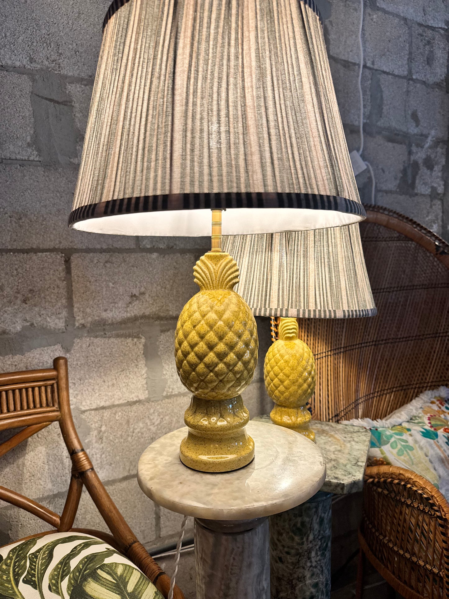 Vintage pineapple table lamp displayed on a marble pedestal with matching lamp behind