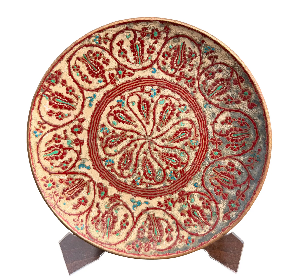 Vintage 12-inch decorative wall plate featuring intricate Persian-style boteh, paisley and floral motifs in crimson, turquoise and cream. Painted enamel or lacquerwork over a copper-toned metal base with hanging loop to reverse.